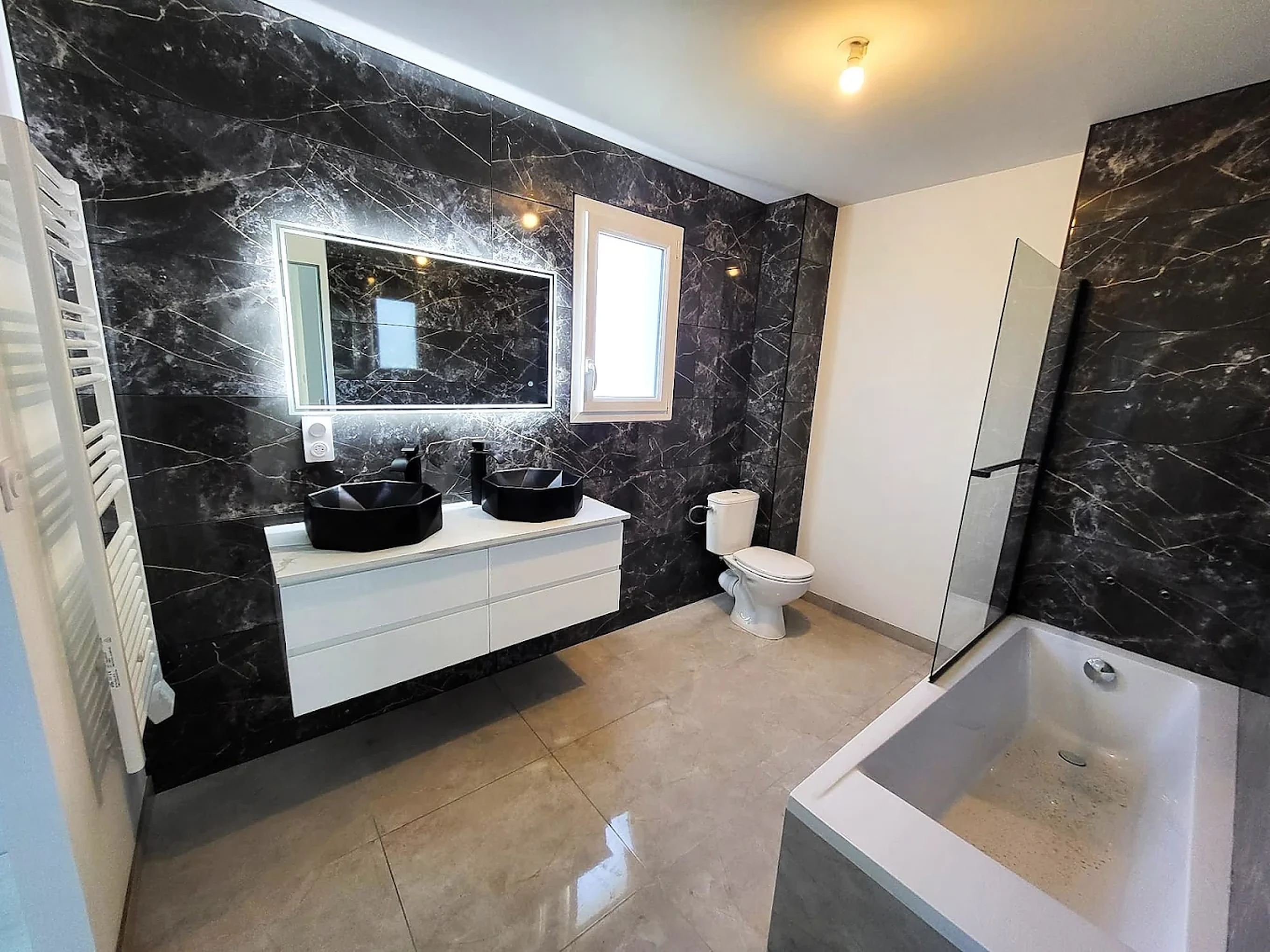 Salle de bain marbre noir avec double vasque et miroir LED