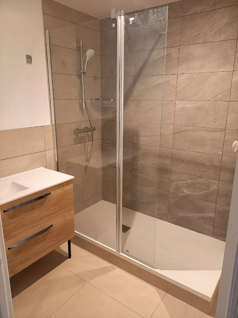 Douche à l'italienne avec meuble vasque en bois et carrelage beige